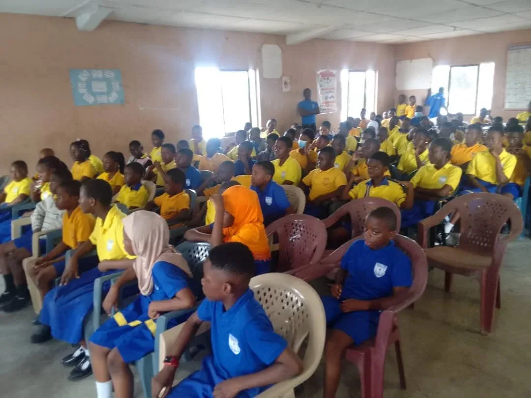 A classroom of students in yellow and blue uniforms at an epilepsy awareness lesson